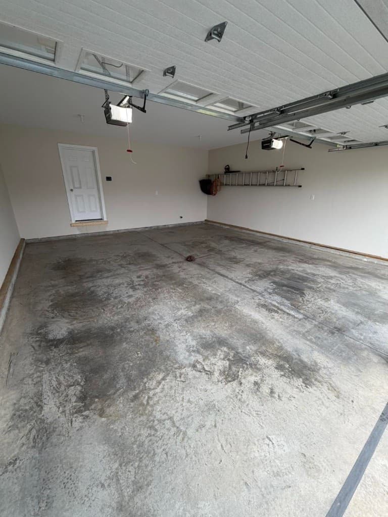 Cracked, stained, and worn bare garage concrete before Nick's Concrete Coating