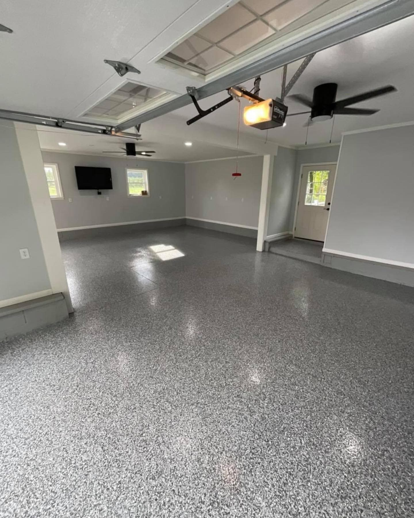 High-gloss gray flake floor in a finished garage and rec room with ceiling fans, Central New York
